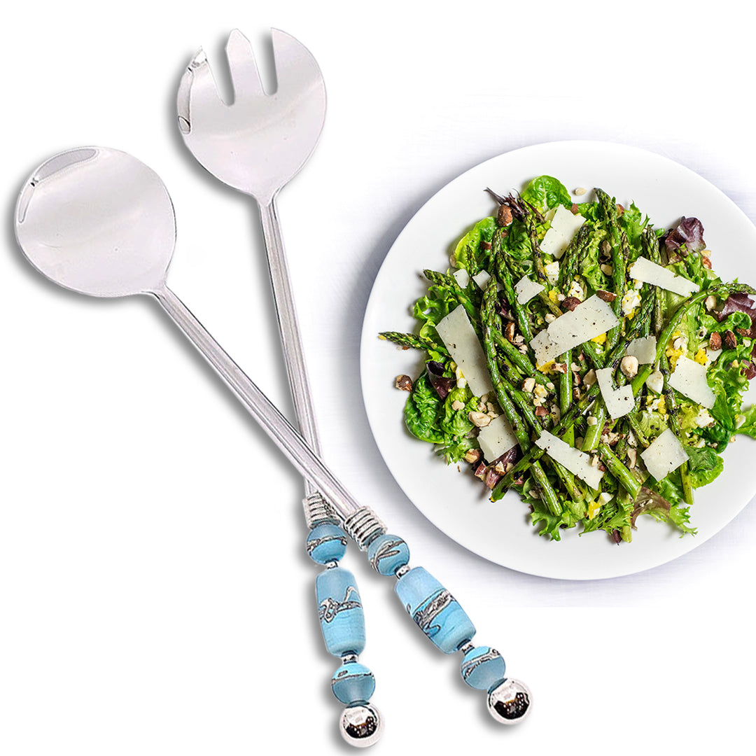 Handcrafted salad servers with smooth handles adorned with glass bead embellishments, offering functionality and elegance for dining experiences. Meticulously crafted for precision, these servers add visual appeal to any table setting, suitable for formal dinners or casual meals, serving salads with sophistication and refined taste. Pictured with asparagus salad.