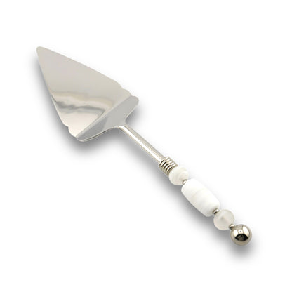 A stainless steel pie server with a handle featuring handcrafted glass beads in various colors.