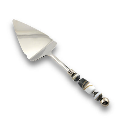 A stainless steel pie server with a handle featuring handcrafted glass beads in various colors.