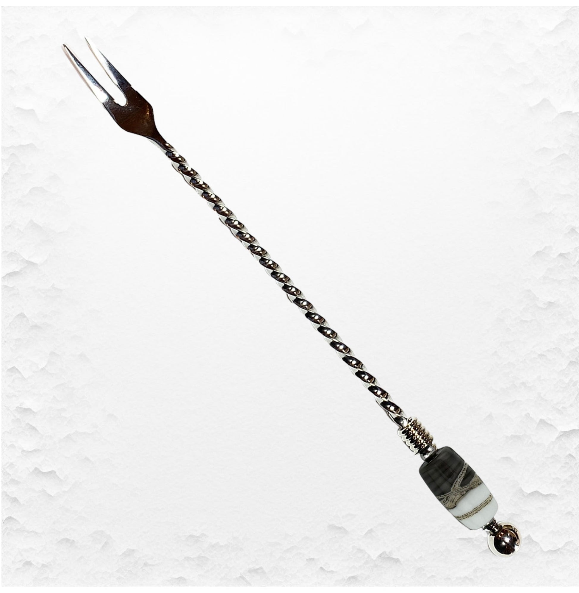 Decorative hairpin with chain and beads on a textured white background