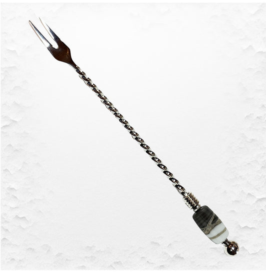 Decorative hairpin with chain and beads on a textured white background