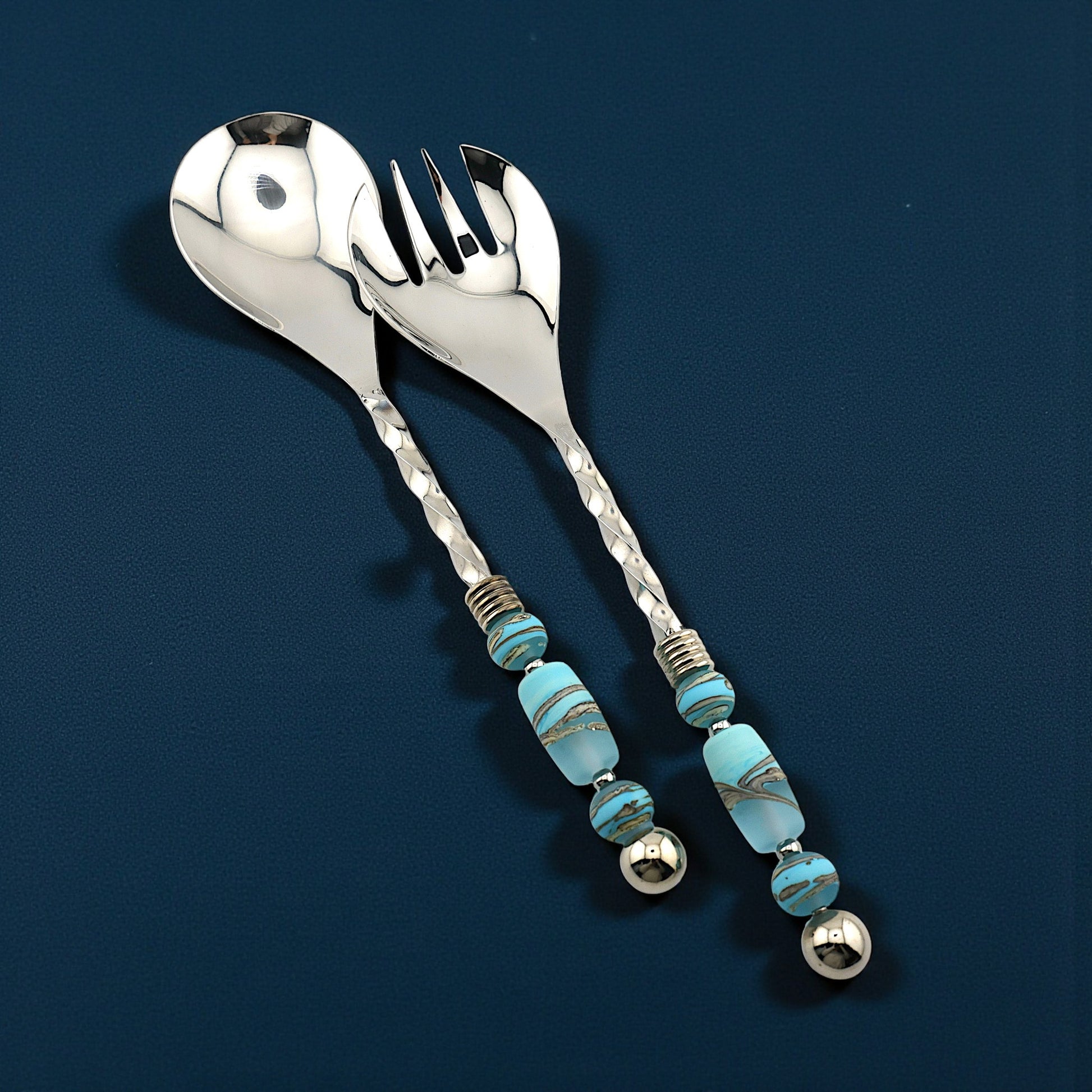 Silver spoon and fork set with turquoise beads on a dark blue background