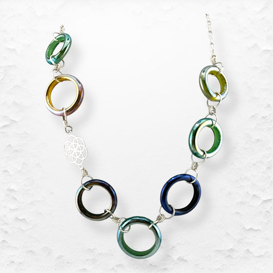 Necklace with colorful circular links on a textured white background